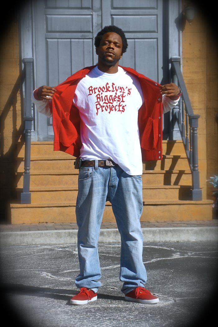 Khing Jus Wurk wearing a red jacket and Brooklyn shirt