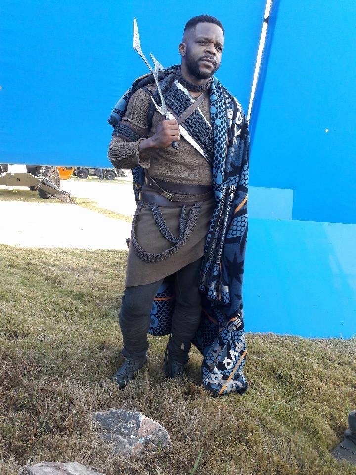Frank Monroe in warrior costume beside a blue-screen set